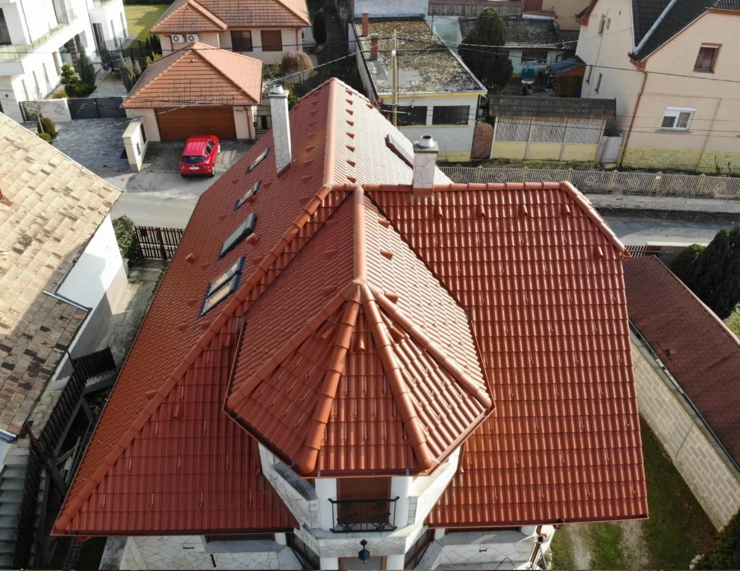 Casă cu acoperiș din țiglă ceramică roșie, văzută din dronă