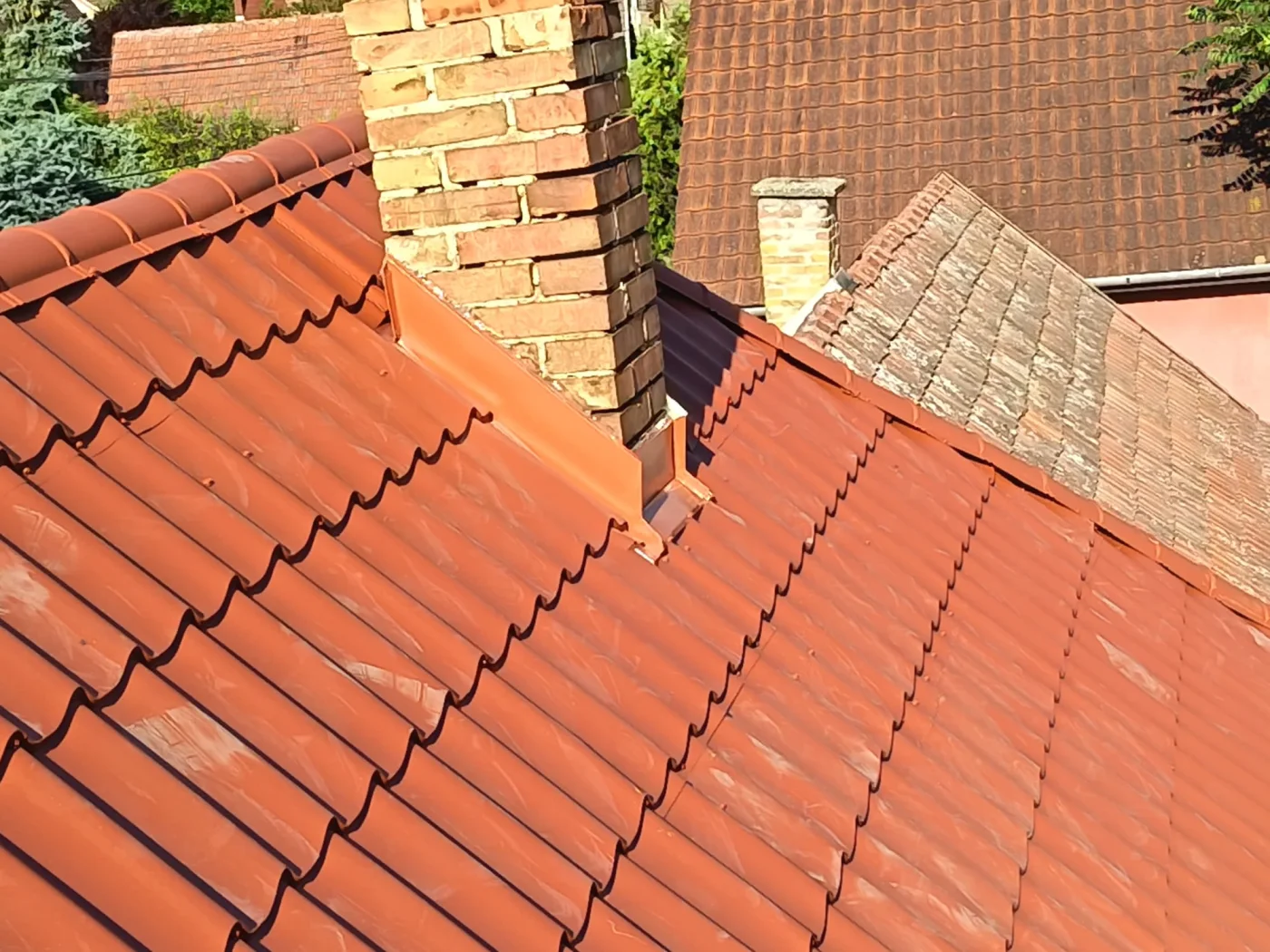 Țiglă ceramică nouă montată lângă un acoperiș vechi