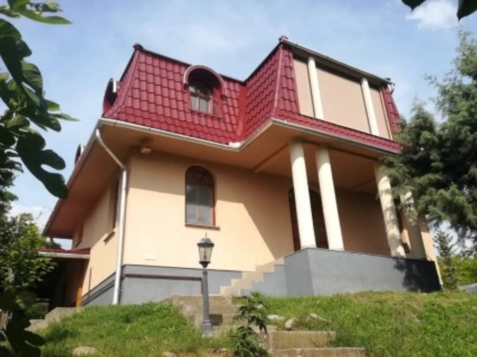 Casă cu acoperiș din țiglă metalică roșie și turnuleț