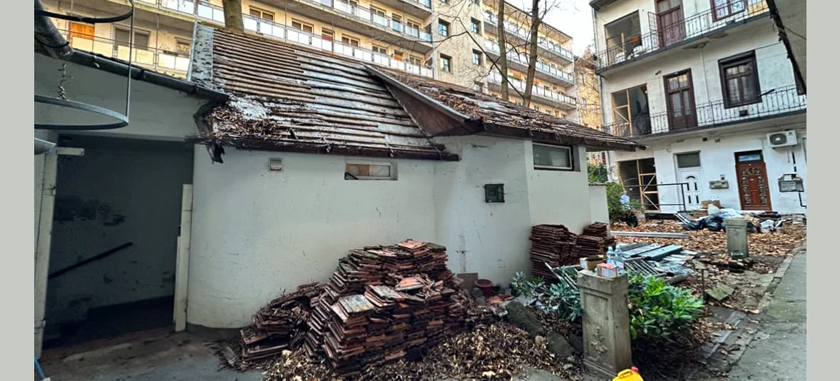 Acoperiș vechi demontat, cu moloz în curte