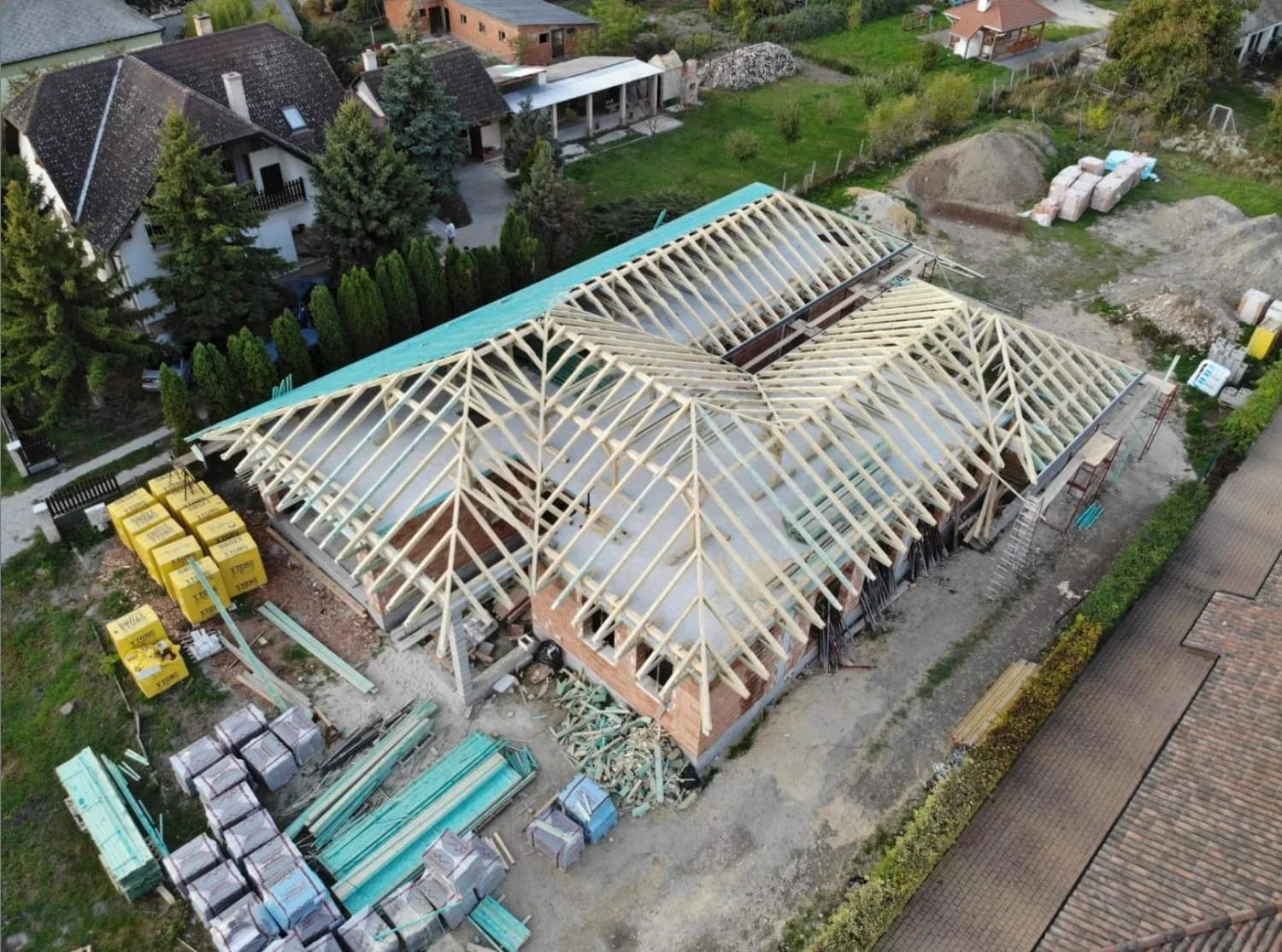 Șarpantă în construcție, cu materialele pe șantier