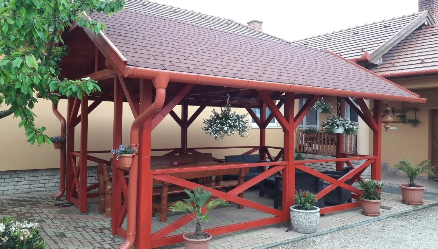 Terasă mare din lemn vopsit, amenajată ca loc de servit masa